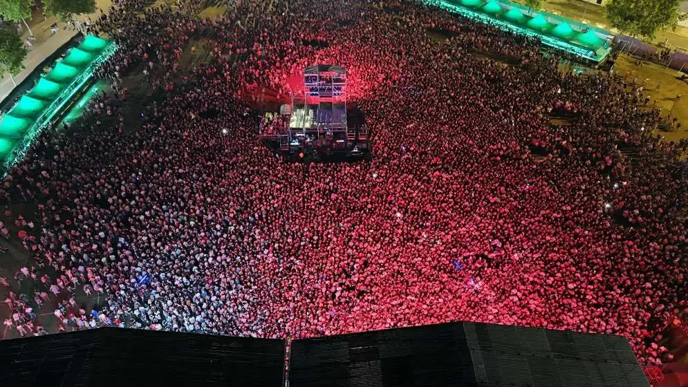 Público iluminado en rojo durante un concierto